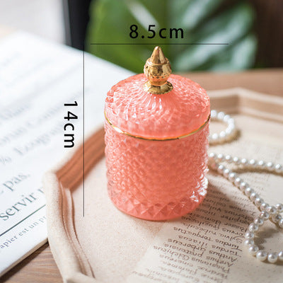 Barattolo di lusso in vetro tagliato finemente con tappo a punta dorata.