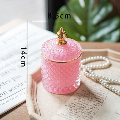 Barattolo di lusso in vetro tagliato finemente con tappo a punta dorata.