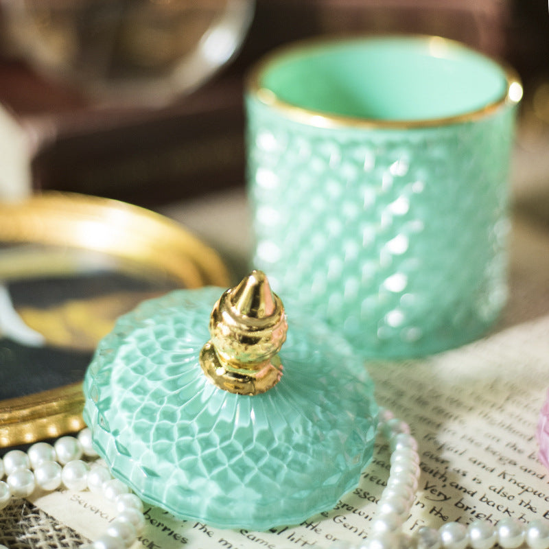 Barattolo di lusso in vetro tagliato finemente con tappo a punta dorata.