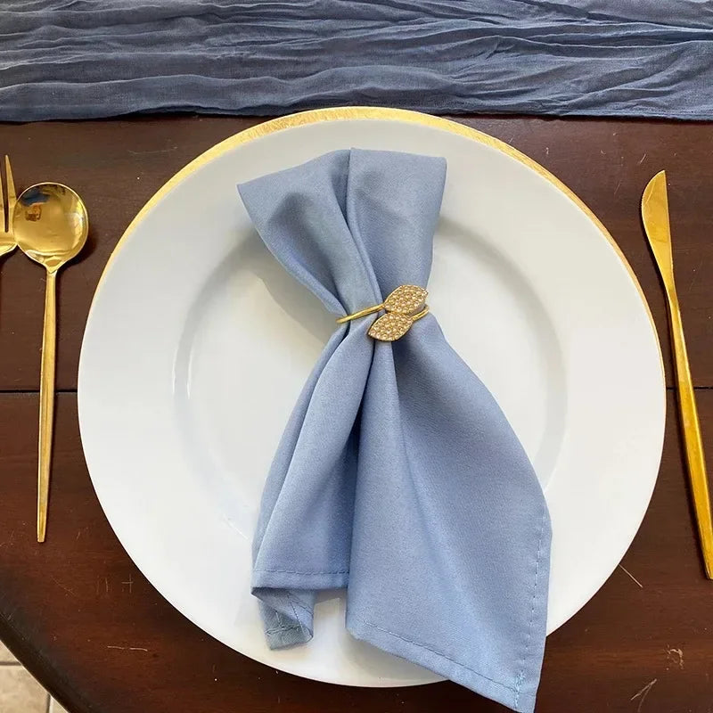 Serviettenringe mit Blättern, elegante Tischdekoration aus Blattgold und Splittern.